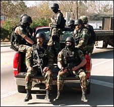 Combat soldiers riding on the back of a pickup truck